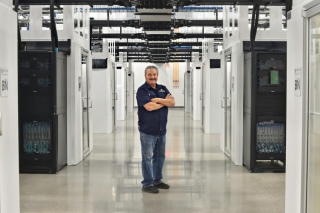 photograph of man with servers at a data center