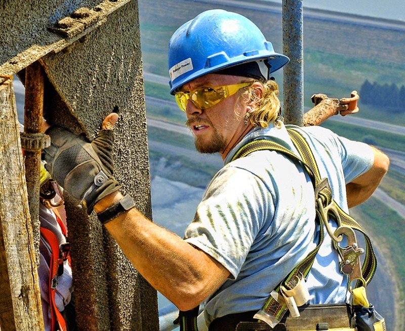 industrial photograph showing man working high up on a building